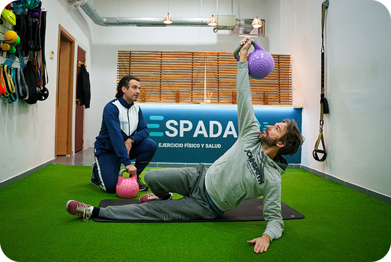 Ejercicio de entrenamiento personal con pesas en centro de entrenamiento ESPADA